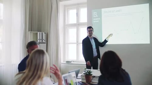 Businessman delivers presentation to colleagues in modern office space