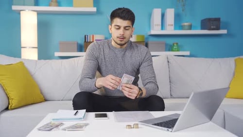 Sad, nervous, young man calculating his financial expenses, suffering from high bills.