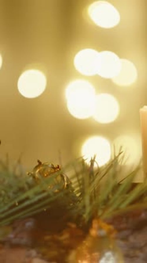 Burning Candle with Christmas Decorations and Bokeh Lights