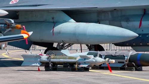 Detailed View of a Military Aircraft's Underwing Pylons with Mounted Fuel Tanks Missiles and Bombs