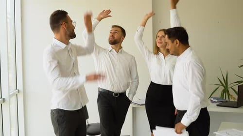 Office Team Celebrates Success with High Five and Hug