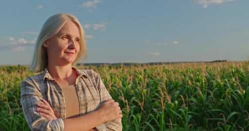 Woman Standing Confidently in Cornfield on Sunny Day