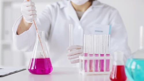Scientist working in lab with colorful liquid
