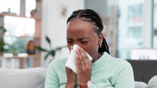 Woman Sneezing While Sitting at Home