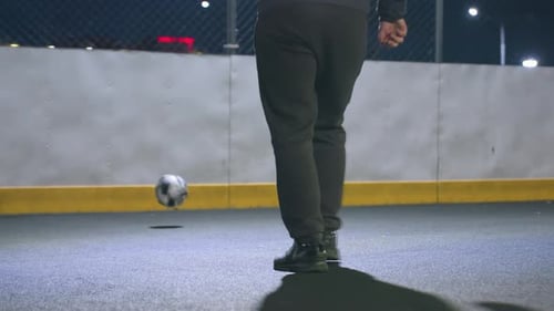 Athlete Kicking Soccer Ball Under Night Stadium Lighting