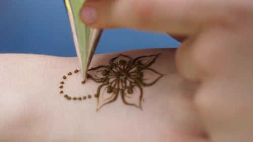 Henna-Künstler, der die Hand einer Frau schmückt. Körperkunst, bekannt als Mehndi. Nahaufnahme