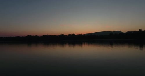 Sunset Over Tranquil Lake with Mountain Backdrop