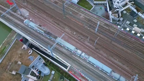 Commuter Train Speeding Through Urban Landscape Aerial View