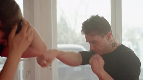 Young Adult Man Boxing with Trainer Indoors