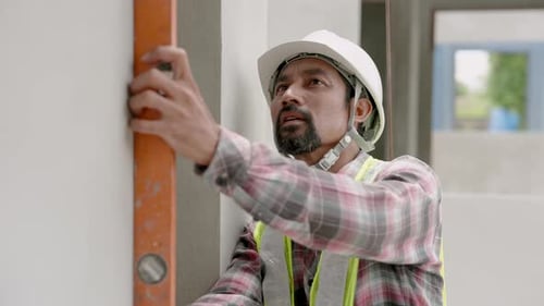 Indian construction engineer with mustache using water level meter Intend to check the slope