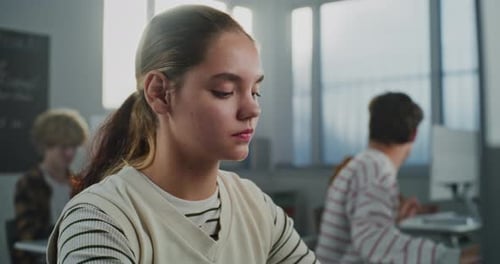 Beautiful Young Student Sits in University Lecture Hall