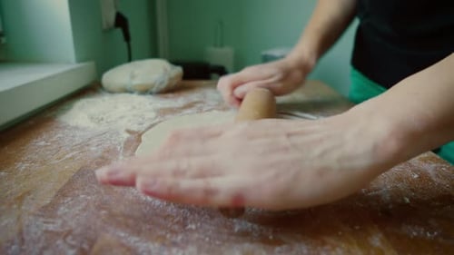 Rolling Dough with Rolling Pin in Kitchen