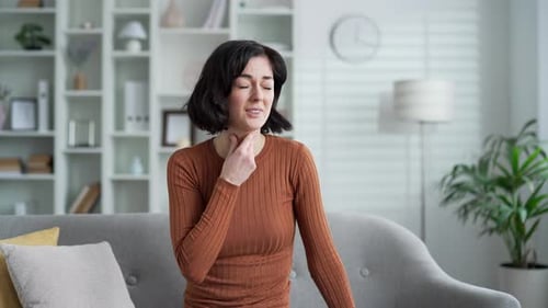 Woman Has Sore Throat in Bright Living Room