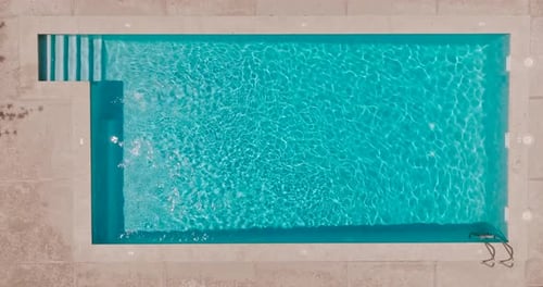 Blue Water in the Swimming Pool with Light Reflections