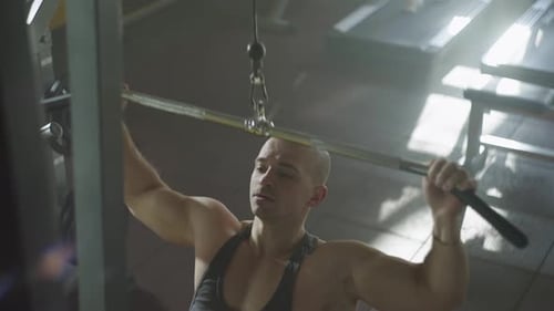 A Pumpedup Young Man Flexes His Back and Arm Muscles on the Exercise Machine