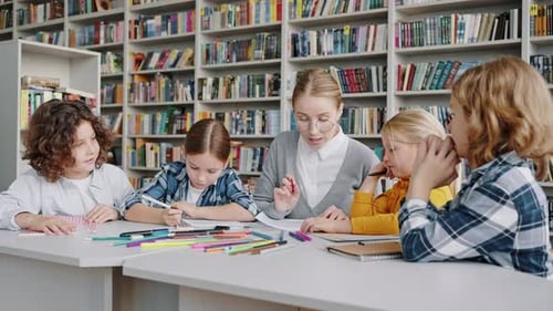 Junge Lehrerin in Brille ermutigt Schüler, Wissen zu erwerben