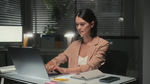 Adicto al trabajo: datos de un informe en una computadora portátil en la oficina por la noche