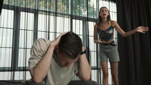 Frustrated Woman Arguing with Man Sitting on Bed
