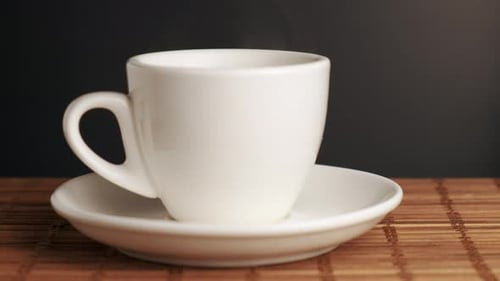 Close Up of Steaming White Teacup and Saucer