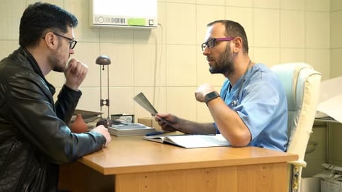 Doctor delivers unhappy brain scan results to patient in hospital office visit