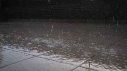 Close Up Of Heavy Rain Pouring Down On Paved Floor.