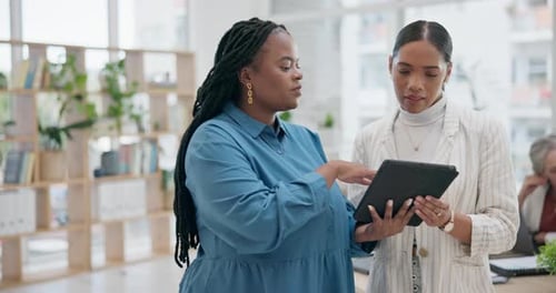 Women Collaborating on a Tablet in Modern Office
