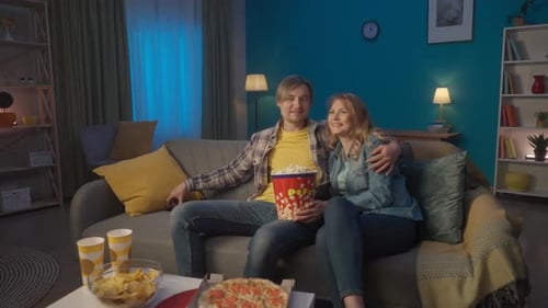 A Young Romantic Couple is Watching a Movie and Eating Popcorn Smiling Man and Woman Hugging and
