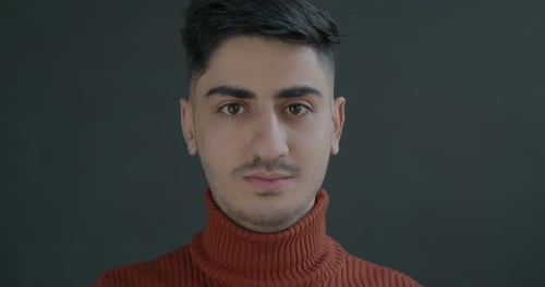 Closeup Portrait of Serious Middle Eastern Man Looking at Camera on Black Background
