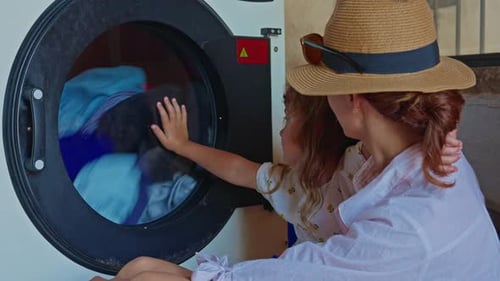 Mother and Child Watching Clothes Wash