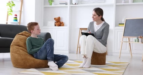 Professional child psychologist working with boy indoors