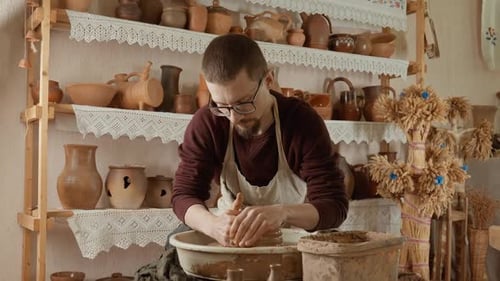 Young Man in Pottery Studio Using Pottery Wheel Potter Shapes Clay Product