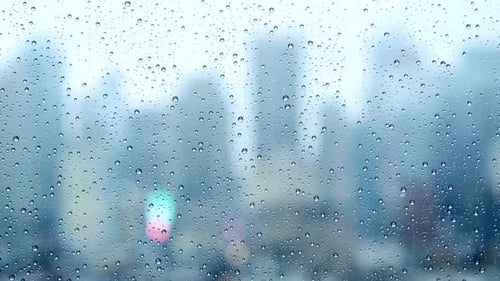 Raindrops on Window with Blurred City Background