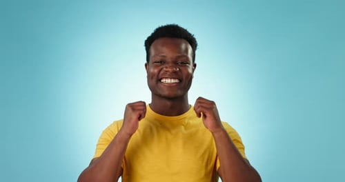 Thumbs up, man and face in studio for support, winning deal and excited achievement on blue