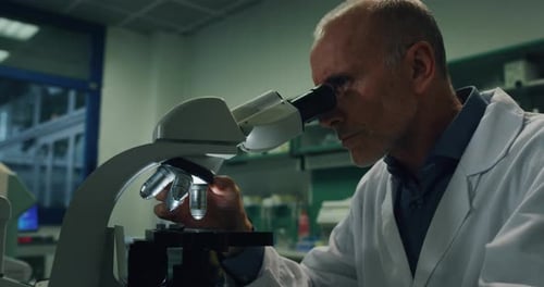 Porträt eines männlichen Wissenschaftlers, der eine Probe analysiert, um DNA und Moleküle mit einem Mikroskop zu extrahieren