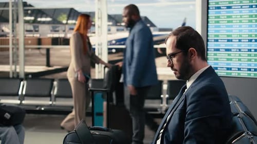 Un homme d'affaires dans la zone d'attente du terminal de l'aéroport travaille sur un ordinateur portable avant le départ