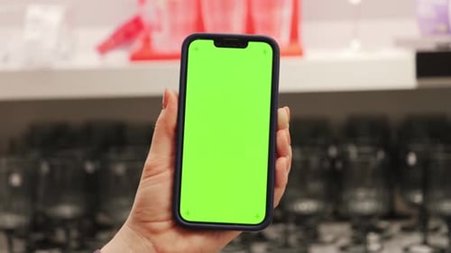 Close Up Hand Use Mobile Smartphone with Vertical Green Screen in Department Store Blurred