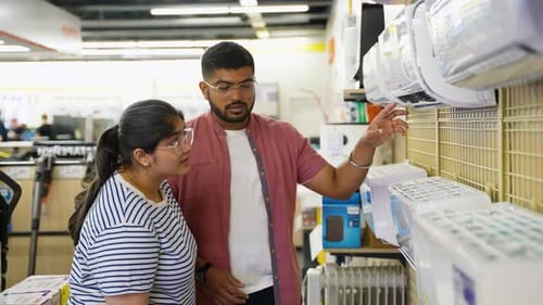 Indian Couple Choosing Air Conditioner in Appliances Store on Black Friday