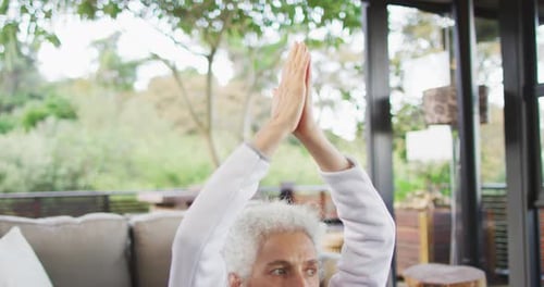 Senior Woman Meditating with Hands Raised