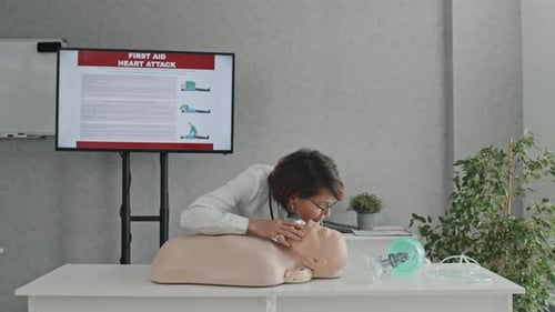 Woman Demonstrates First Aid on Mannequin