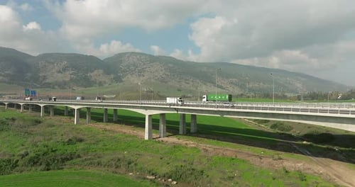 Day traffic on a countryside bridge surrounded by lush green landscape