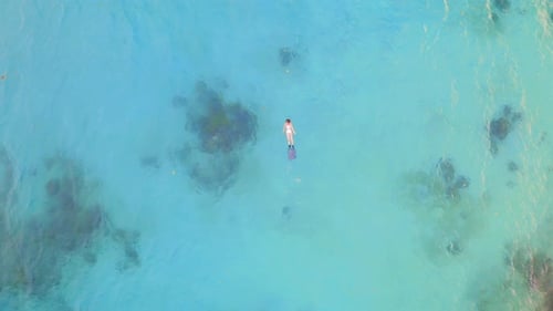 Séquence vidéo 4k d'une femme méconnaissable faisant de la plongée avec tuba dans la mer pendant la journée