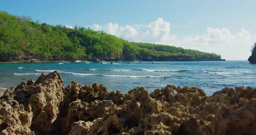 Felsige Küste, Nahaufnahme der grünen Insel Nusa Penida, Crystal Bay Beach mit Klippenküste in Indonesien