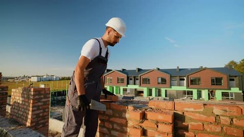 Builder Laying Bricks and Checking Level Accuracy