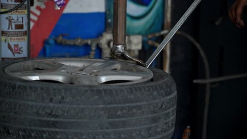Mechanic Removing Tire From Rim Using Machine