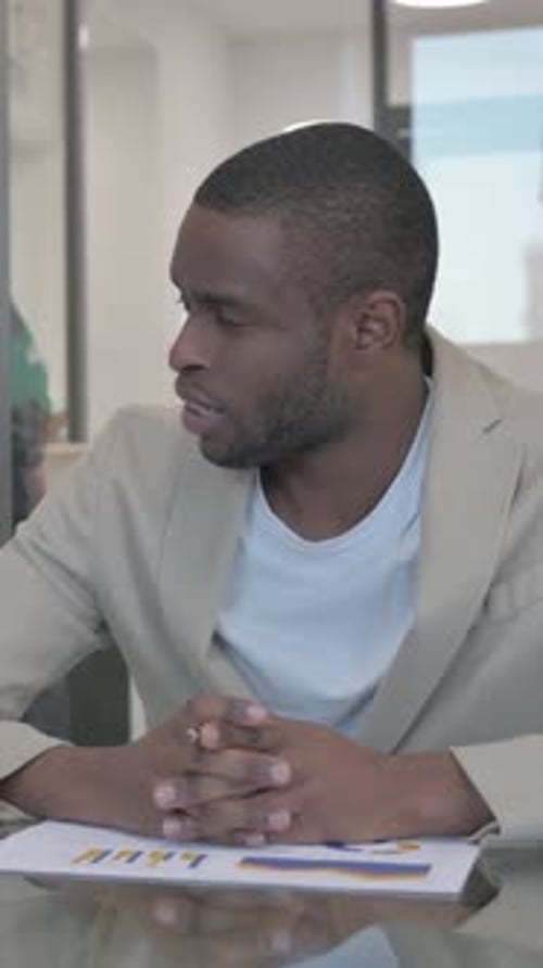 Man in Blazer Discussing Charts at Business Meeting