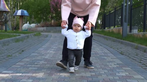 Cute Infant Learning to Walk in the Park