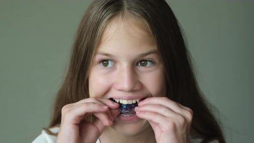 Teenage Girl Puts on Orthodontic Apparatus and Smiling