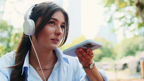 Woman Records Audio Message on Smartphone in Park
