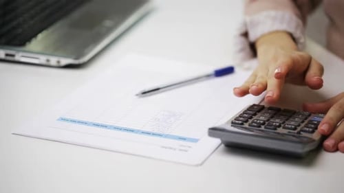 Businesswoman works with laptop calculator and accounting documents in office