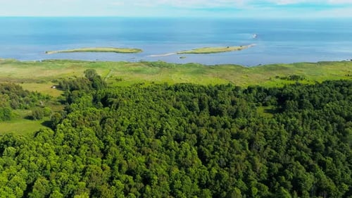 Flying over a forest towards two islands close to the coast, Baltic sea
